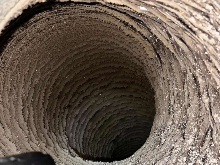 Inside a flexible duct whose walls are caked with lint, the kind of run that often has to be replaced